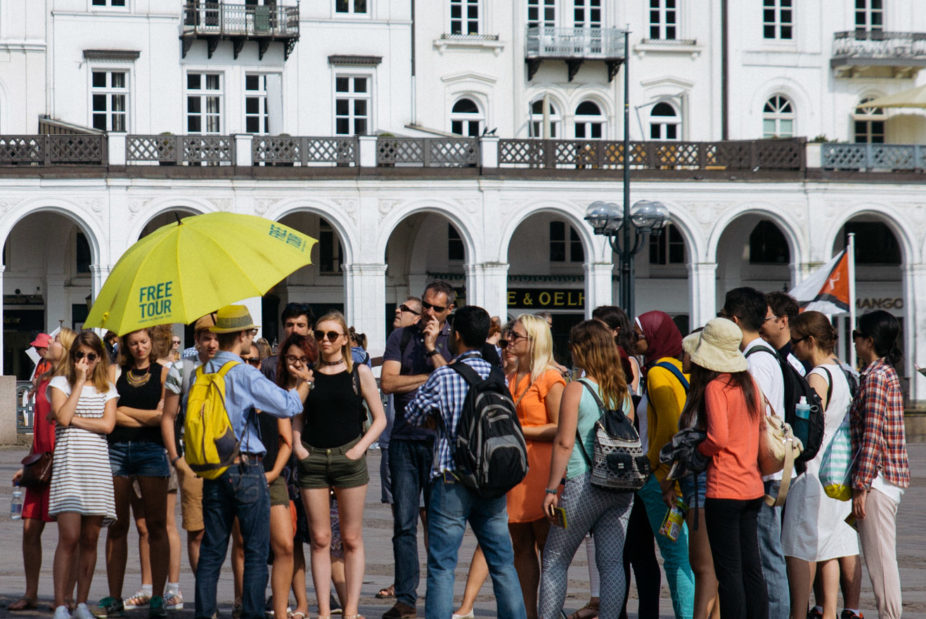 Deutscher Stadtführer mit gelbem Schirm spricht über Guruwalk Hamburg